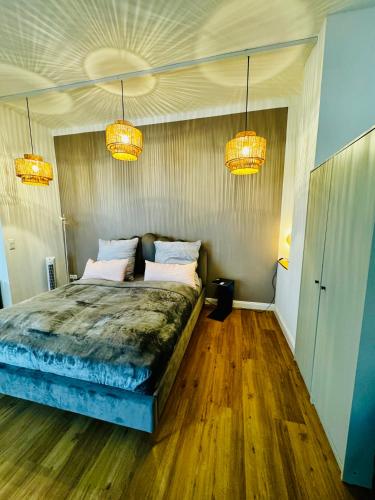 a bedroom with a bed with two pillows and two lights at Room107 im Herzen von MA Seckenheim in Mannheim