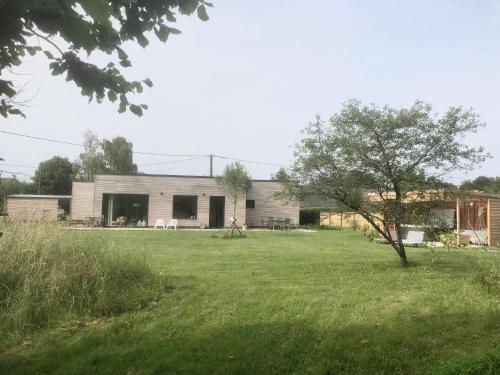 une maison avec une grande cour avec un arbre dans l'établissement Maison design à la campagne, à Pont-de-Ruan