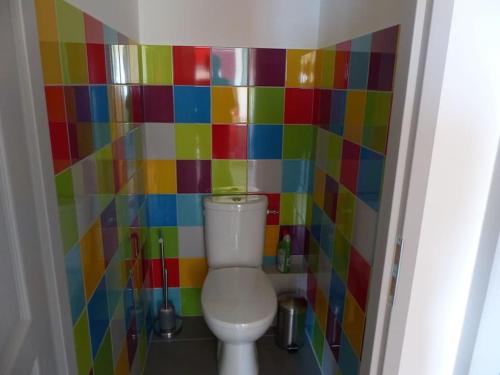 a bathroom with a colorful tiled wall next to a toilet at Appart agréable près d'Embrun in Chateauroux-les-Alpes