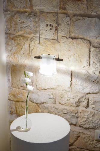 a lamp and a vase with a flower on a table at B&B Morabella in Conversano