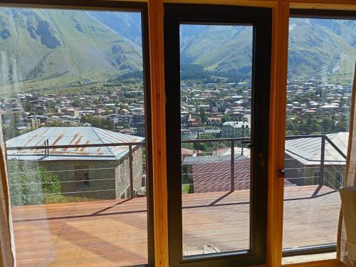 an open glass door with a view of a city at My house in Stepantsminda