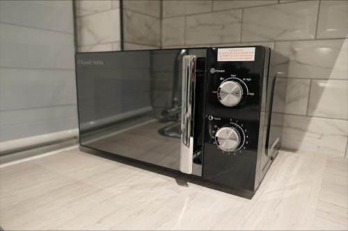 a microwave oven sitting on top of a floor at Premium London Apartment - 10 minutes from Wembley Stadium, OVO Wembley Arena in London