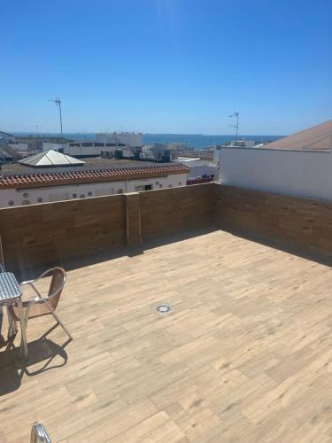 a patio with a table and chairs on a roof at Hotel La Parrita in Rota