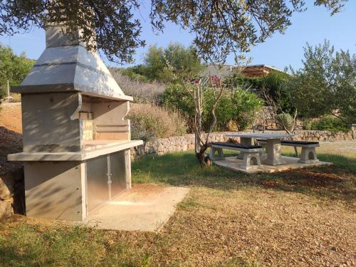 a picnic table and a bird house in the grass at Holiday Homes Kanajt in Punat