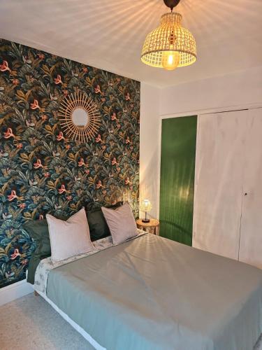 - une chambre avec un grand lit et du papier peint floral dans l'établissement beau t2 proche plage et commerces, logia, à La Grande Motte