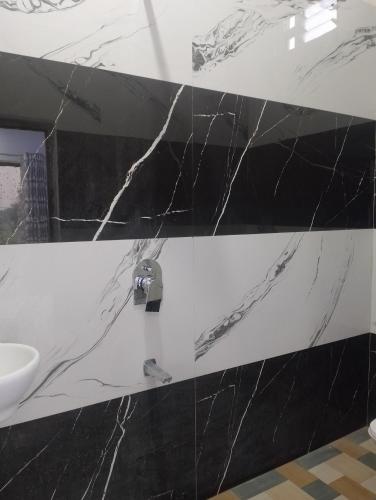 a bathroom with a black and white marble wall at Hotel Moonlight & Restaurant in Sehore