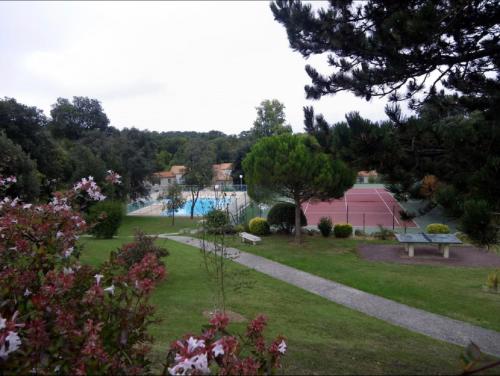 un parc avec un banc et une piscine dans l'établissement Maison Familiale bord de mer, à Meschers-sur-Gironde