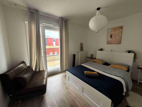 une chambre avec un lit, une chaise et une fenêtre dans l'établissement L'Elégance Parisien, à Saint-Ouen