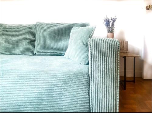 un canapé avec des oreillers à rayures bleues et une table dans l'établissement Cocon Avignonnais au Cœur du Centre Historique, à Avignon