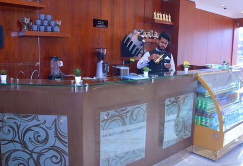 a man standing behind a bar in a restaurant at Art Suite in Riyadh