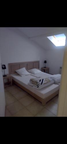 une chambre avec un grand lit avec des draps blancs dans l'établissement Appartement Corse, à Santa-Maria-Poggio