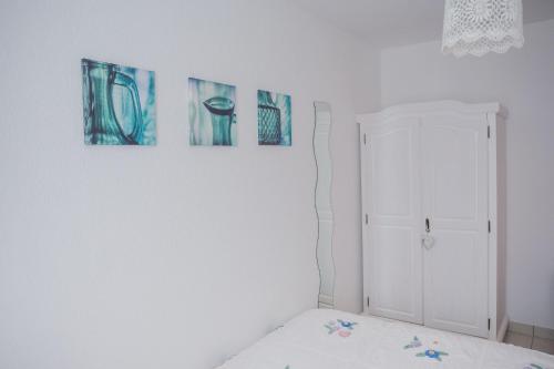 a bedroom with three paintings on the wall at Romantische Ferienwohnung in Wüstenrot