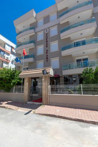 a hotel building with a sign in front of it at Toprak Otel in Antalya