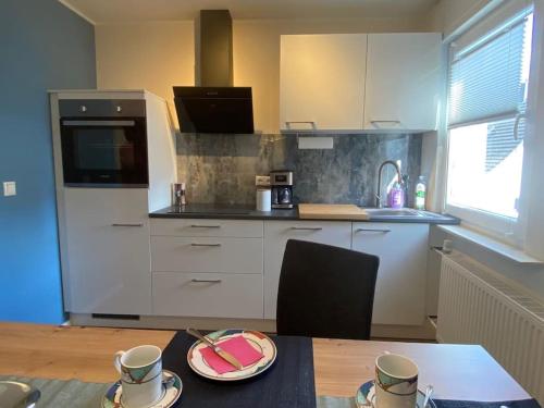 a kitchen with a table with cups and plates on it at Ferienwohnung in ruhiger Lage in Bad Camberg
