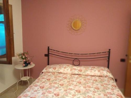 a bedroom with a bed with a pink wall at la casa di Rosa in Selvatelle