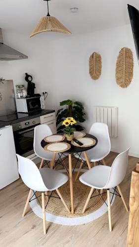 a kitchen with a table and four chairs in a kitchen at Magnifique deux pièces au cœur de espaly Saint-Marcel in Espaly-Saint-Marcel