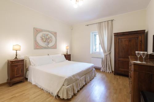 a bedroom with a large white bed and a window at Massimago Wine Relais in Mezzane di Sotto