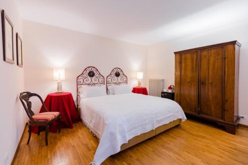 a bedroom with a bed and two tables and a chair at Massimago Wine Relais in Mezzane di Sotto