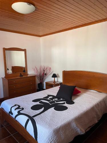 a bedroom with a bed with a black and white blanket at Casa mãe in Lajes do Pico
