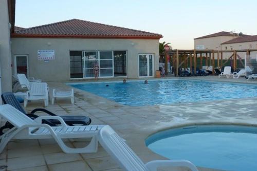 une piscine avec des chaises longues et une piscine dans l'établissement Maisonnette 43m2 piscine Gallargues le montueux, à Gallargues-le-Montueux
