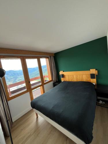 - une chambre dotée d'un lit avec un mur vert dans l'établissement Apartment Paradiski 309 - La Plagne - ski-in, ski-out, à La Plagne Tarentaise
