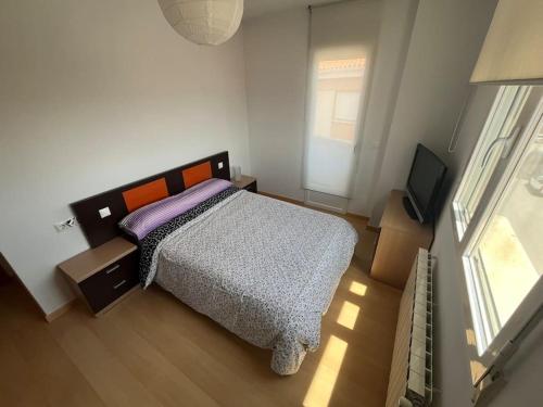 a bedroom with a bed and a flat screen tv at Piso 3 Dormitorios in La Roda