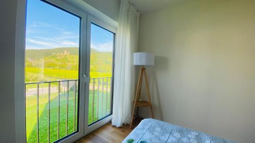 a bedroom with a large window with a view of a field at Haus im Weinberg in Ellenz-Poltersdorf