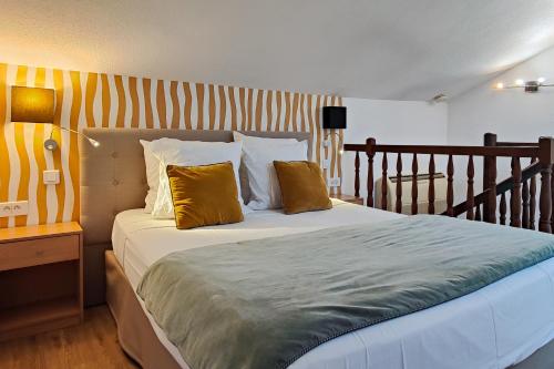 a bedroom with a bed with yellow and white pillows at Aparthotel AMMI Nice Massena - ex Ajoupa in Nice