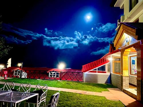 a patio with a table and chairs at night at Hotel Rollingrang in Kalpa