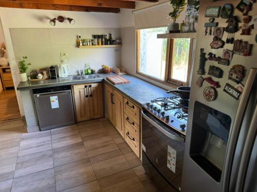 a small kitchen with a stove and a refrigerator at Casa Como Vaca El Chalten in El Chalten