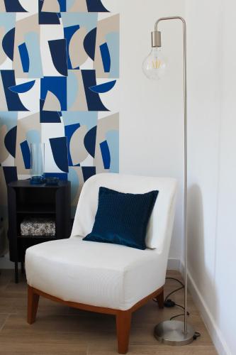 a white chair in a room with a blue wall at B&B Blue Luxury Suite in Avellino