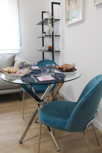 a glass table with two blue chairs and food on it at B&B Blue Luxury Suite in Avellino