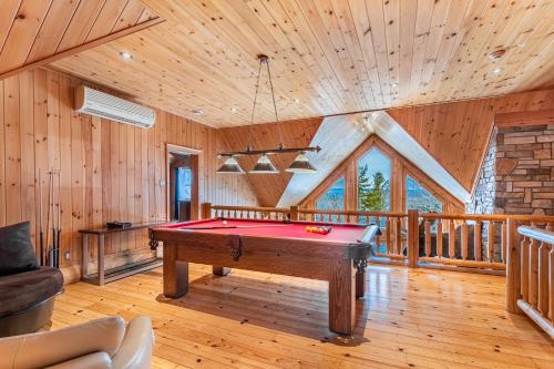 a pool table in a room with wooden walls at Fiddler Lake Resort - Moose 93 in Mille-Isles