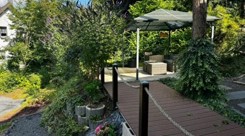 a wooden deck with an umbrella and some plants at AR Apartments - 1898 in Coburg