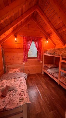 a bedroom with two beds in a wooden cabin at ABBA Ethno House in Gusinje