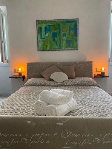 a bed with two rolled towels on it with two lamps at Echoes room 20 minuti dal centro di Firenze in Prato