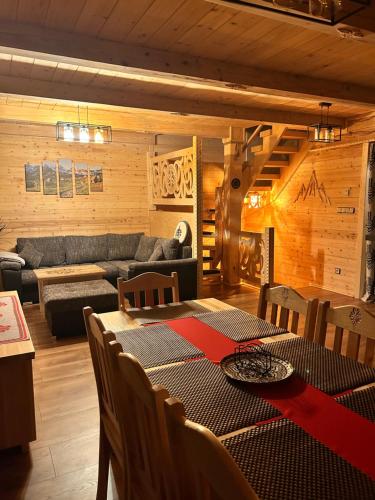 a living room with a table and a couch at Leśne Zacisze & Spa na wyłączność in Lubień
