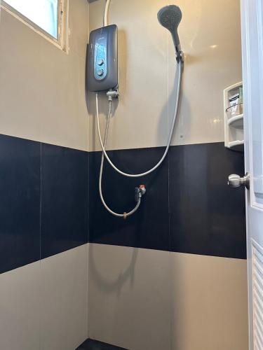 a shower in a bathroom with a tv on the wall at New Warm Light Hostel in Chiang Mai
