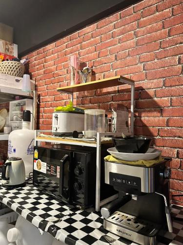 a kitchen with a brick wall and a counter top at New Warm Light Hostel in Chiang Mai