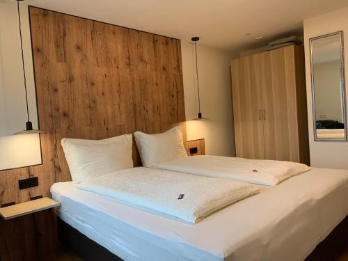 a bedroom with a large bed with a wooden headboard at Gästehaus Baldauf in Berwang