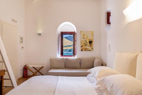 a white room with a couch and a window at Pirgos Mavromichali in Limeni
