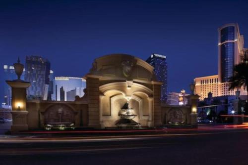 a building with a fountain in front of a city at night at Marriott Grand Chateau 2BD in Las Vegas