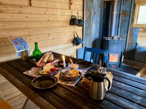 a wooden table with food and candles on it at Offroadcamp in Sörsjön