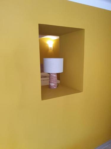 un mur jaune avec une lampe dans une pièce dans l'établissement T2 neuf, RDJ dans villa sous les pins, port Carry, jardin terrasse indépendants, à Carry-le-Rouet