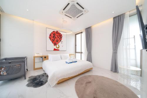 a white bedroom with a bed and a fireplace at Andaman Villa 15 minutes from Bangtao Beach in Phuket Town