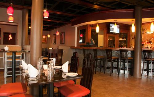 un restaurante con mesas y sillas y un bar en Sandy Haven Resort en Negril