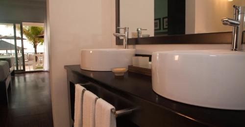 
a bathroom with a sink and a mirror at Sandy Haven Resort in Negril
