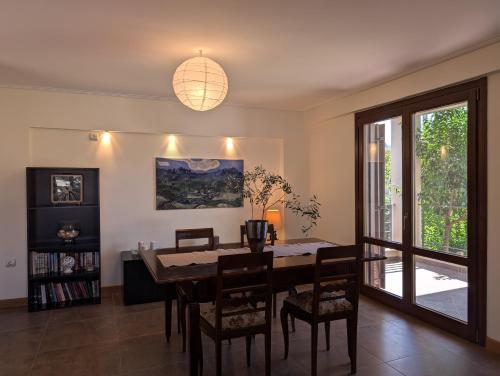 a dining room with a table and chairs and a window at Luxury Villa in Nature - Akrata Village in Akrata