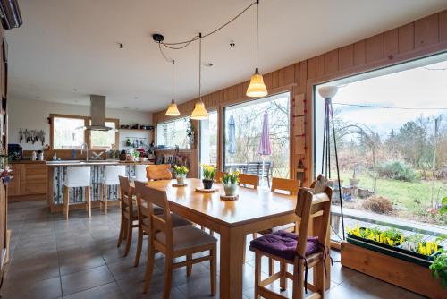 une cuisine et une salle à manger avec une table et des chaises en bois dans l'établissement Les Gourmandises Bio, à Recologne