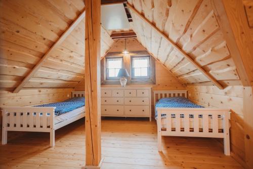 a bedroom with two beds in a wooden attic at Drevenica Liptovské Behárovce in Liptovské Beharovce
